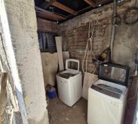 Logia cerrada de material solido con radier a un costado del patio