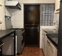 Cocina con vista hacia puerta de salida, acceso a logia