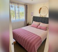 Dormitorio principal con cama de dos plazas y ventana.