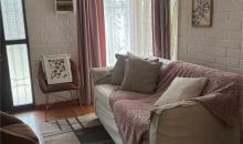 Linving espacioso que resalta el ingreso de luz natural por 2 vías