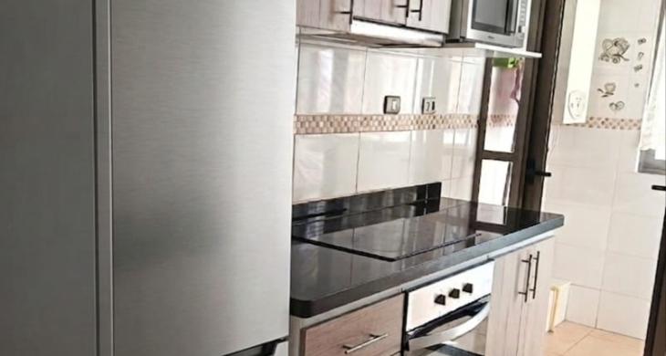 Cocina se extiende hasta logia, donde se instala calefont y lavadora.
