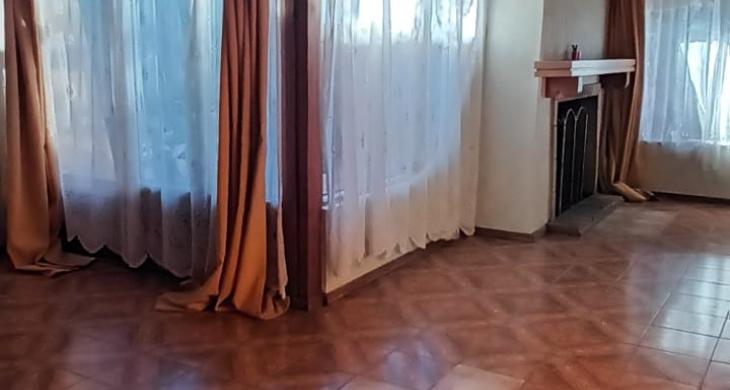 Hermoso living comedor iluminado con amplios ventanales, chimenea ubicada en sector de living, en su interior construida en madera con vigas a la vista, conserva lampara original 
