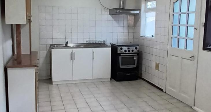 amplia cocina amoblada que conecta con living- comedor y puerta que conecta hacia comedor diario