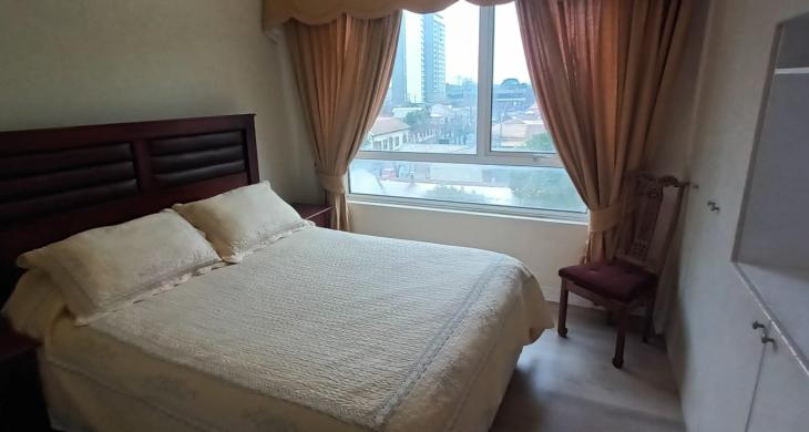 HABITACION PRINCIPAL CON CAMA DE 2 PLAZAS CON ELEGANTE ROPA DE CAMA 2 VELADORES Y CORTINAS CON CENEFA BIEN TERMINADAS QUE DECORAN EL AMBIENTE DE MANERA ACOGEDORA