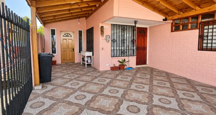 Vista del patio techado, con piso de baldosas y acceso a la vivienda.